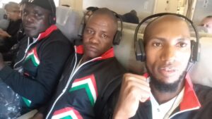 Three men take a selfie inside an aeroplane